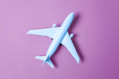 Kısaca düz dizayn edilmiş oyuncak uçak. 2020 'nin modaya uygun renginde. Mor mor arka planda Klasik Mavi. Parlak Makro rengi 19-4052. Uçak yolculuğu seyahat bileti konsepti