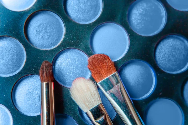 Werkzeuge für Make-up und Kosmetik verschiedene Schattierungen der Lidschatten-Palette in der Trendfarbe des Jahres 2020 klassisches Blau gefärbt. helles Makro mit Farbe 19-4052. Draufsicht flach und malerisch — Stockfoto