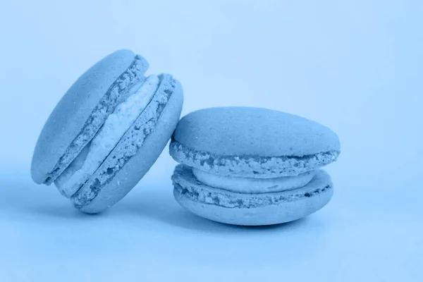 Słodki migdałowy makaron lub makaron ciasto deserowe kolorowe w modnym kolorze roku 2020 Classic Blue izolowane na niebieskim pastelowym tle. Makro używając koloru 19-4052. Przestrzeń kopiowania — Zdjęcie stockowe