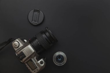 Karanlık masa arka planında DSR kamera sistemi ve lensleri olan fotoğrafçı işyeri. Hobi seyahat fotoğrafçılık konsepti. Düz görünüm kopyalama alanı.