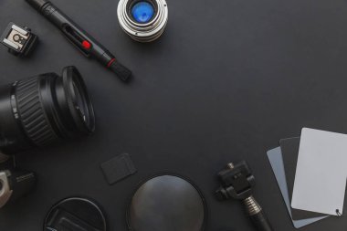 DSR kamera sistemi olan fotoğrafçı işyeri, kamera temizleme seti, siyah masa arka planında lens ve kamera aksesuarı. Hobi seyahat fotoğrafçılık konsepti. Düz görünüm kopyalama alanı.