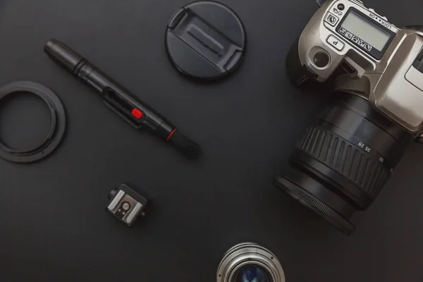 Fotograaf werkplek met dslr camerasysteem, camera schoonmaak kit, lens en camera accessoire op donker zwarte tafel achtergrond. Hobby reisfotografie concept Flat lay bovenaanzicht kopieerruimte — Stockfoto