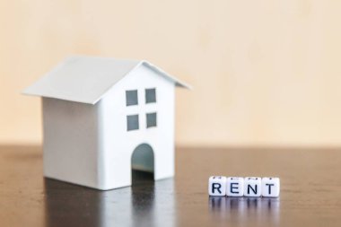 Minyatür oyuncak model ev kira harf kelime ahşap zemin üzerinde yazıt ile. Eko Köyü, çevre arka plan. Emlak mortgage Emlak sigorta tatlı ev ekoloji kira kavramı