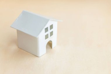 Ahşap zemin üzerinde minyatür oyuncak model ev. Eco Village soyut çevre geçmişi. Gayrimenkul ipoteği emlak sigortası tatlı ev ekolojisi kavramı