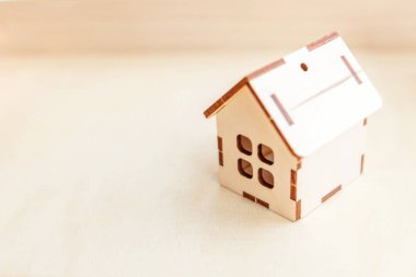 Ahşap zemin üzerinde minyatür oyuncak model ev. Eco Village soyut çevre geçmişi. Gayrimenkul ipoteği emlak sigortası tatlı ev ekolojisi kavramı