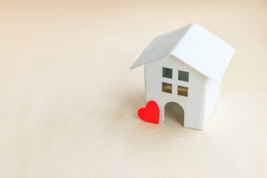 Ahşap zemin üzerinde kırmızı kalbi olan minyatür oyuncak model ev. Eco Village soyut çevre geçmişi. Gayrimenkul ipoteği sigortası tatlı rüya ev ekolojisi kavramı