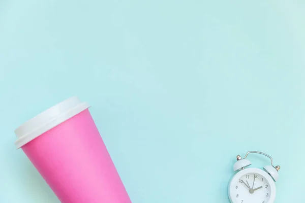 Jednoduše plochý design růžový papírový šálek a budík izolovaný na modré pastelové barevné pozadí — Stock fotografie