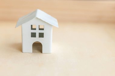 Ahşap zemin üzerinde minyatür oyuncak model ev. Eco Village soyut çevre geçmişi. Gayrimenkul ipoteği emlak sigortası tatlı ev ekolojisi kavramı