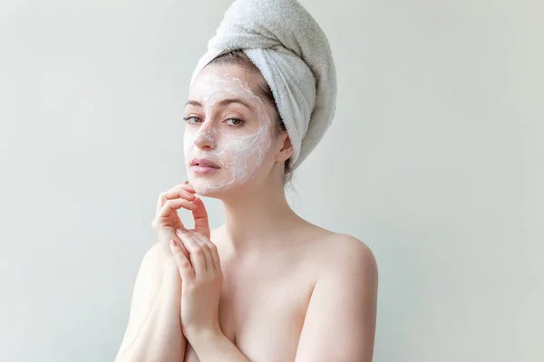 Muchacha de belleza mínima en toalla sobre retrato de cabeza aplicando mascarilla nutritiva blanca o crema en la cara aislada sobre fondo blanco. Limpieza de la piel ecológica concepto de spa cosmético orgánico . —  Fotos de Stock