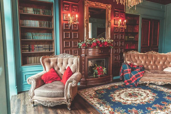 Interior clássico de luxo da biblioteca doméstica. Sala de estar com estante, livros, cadeira de braço, sofá e lareira — Fotografia de Stock