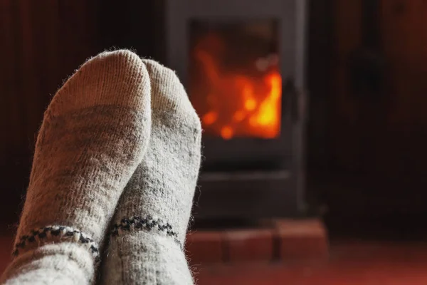 Nogi stóp w zimowe ubrania Skarpety wełniane na ognisko w domu na zimę lub jesienią wieczorem relaks i rozgrzewka — Zdjęcie stockowe