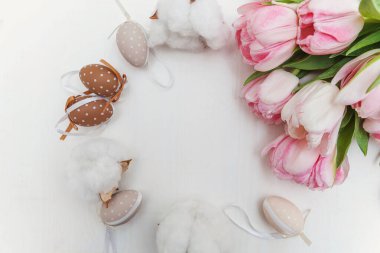 Paskalya yumurtaları yosun pamuklu ve pembe taze lale buketli.