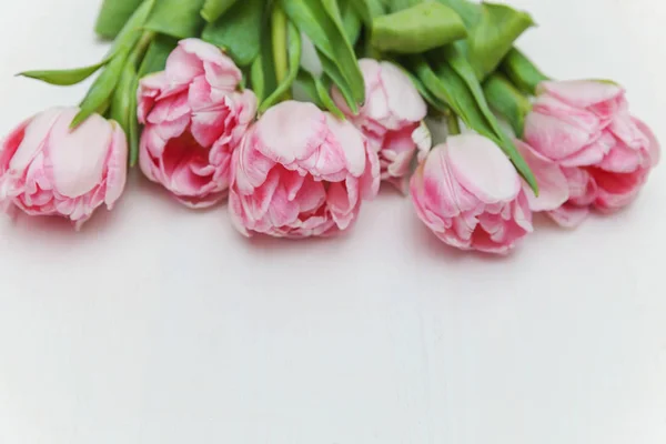 Букет з свіжих рожевих тюльпанів на сільській білій дерев'яній спині — стокове фото