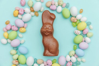 Mutlu Paskalya konsepti. Tatile hazırlık. Paskalya şeker çikolata yumurta tavşan ve jellybean tatlılar trendy pastel mavi arka plan izole. Basit minimalizm düz üst görünüm kopyalama alanı yatıyordu.