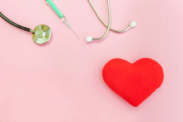 Equipamento de medicina estetoscópio ou seringa de fonendoscópio e coração vermelho isolado no moderno fundo rosa pastel — Fotografia de Stock