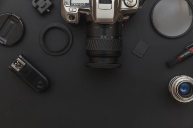 DSR kamera sistemi olan fotoğrafçı işyeri, kamera temizleme seti, siyah masa arka planında lens ve kamera aksesuarı. Hobi seyahat fotoğrafçılık konsepti. Düz görünüm kopyalama alanı.