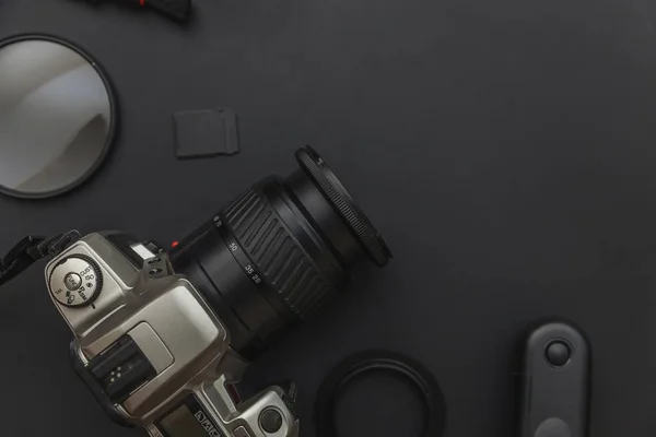Dslrカメラシステム、カメラクリーニングキット、暗い黒いテーブルの背景にレンズとカメラアクセサリーを持つ写真家の職場。趣味旅行写真の概念。フラットレイアウトトップビューコピースペース. — ストック写真