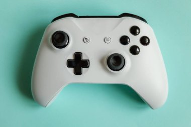 Siber uzay sembolü. Beyaz joystick oyun sahası, pastel mavi renkli arka planda izole edilmiş oyun konsolu. Bilgisayar oyunu yarışması video oyunu kontrol yüzleşme kavramı.