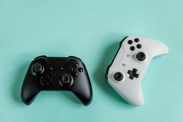 Putih dan hitam dua joystick gamepad, konsol permainan terisolasi di pastel biru latar belakang trendi berwarna-warni. Konsep konfrontasi game game game game komputer. Simbol cyberspace . — Stok Foto