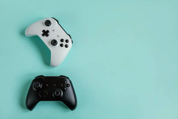 Blanco y negro dos joystick gamepad, consola de juegos aislada sobre fondo de moda de color azul pastel. Concurso de juegos de ordenador concepto de confrontación de control de videojuegos. Símbolo del ciberespacio . — Foto de Stock