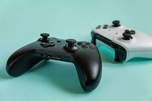 Branco e preto dois joystick gamepad, console de jogo isolado no fundo da moda colorida azul pastel. Concorrência de jogos de computador conceito de confronto de controle de videogame. Símbolo ciberespaço . — Fotografia de Stock