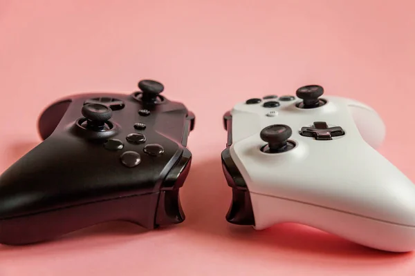 Cyberspace symbool. Wit en zwart twee joystick gamepad, spelcomputer op pastel roze kleurrijke trendy pin-up achtergrond. Computer gaming concurrentie videogame controle confrontatie concept. — Stockfoto
