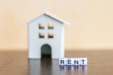 Minyatür oyuncak model ev kira harf kelime ahşap zemin üzerinde yazıt ile. Eko Köyü, çevre arka plan. Emlak mortgage Emlak sigorta tatlı ev ekoloji kira kavramı