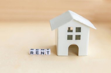 Minyatür oyuncak model ev kira harf kelime ahşap zemin üzerinde yazıt ile. Eko Köyü, çevre arka plan. Emlak mortgage Emlak sigorta tatlı ev ekoloji kira kavramı