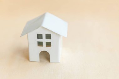 Ahşap zemin üzerinde minyatür oyuncak model ev. Eco Village soyut çevre geçmişi. Gayrimenkul ipoteği emlak sigortası tatlı ev ekolojisi kavramı