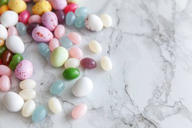 Mutlu Paskalyalar. Tatil için hazırlık. Paskalya çikolatalı yumurtalar ve jöleli şekerler moda gri mermer arka planda. Basit minimalizm düz üst görünüm kopyalama alanı.