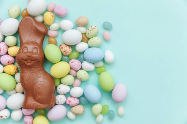Mutlu Paskalya konsepti. Tatile hazırlık. Paskalya şeker çikolata yumurta tavşan ve jellybean tatlılar trendy pastel mavi arka plan izole. Basit minimalizm düz üst görünüm kopyalama alanı yatıyordu.