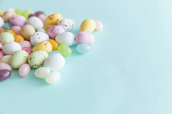 Feliz concepto de Pascua. Preparación para las vacaciones. Huevos de chocolate con caramelos de Pascua y dulces de gelatina aislados sobre un fondo azul pastel de moda. Minimalismo simple plano laico vista superior copia espacio. — Foto de Stock