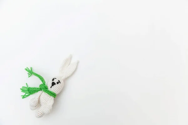 Design tout simplement minimal avec lapin jouet en écharpe verte isolée sur fond blanc. Les enfants prennent soin de la maternité concept familial. Pose plate, vue du dessus, espace de copie — Photo