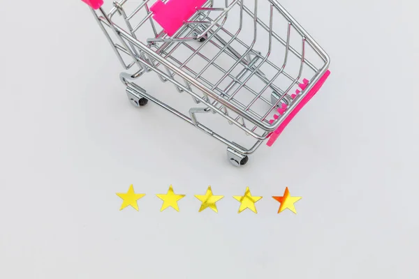 Malý supermarket nákupní vozík pro nákupy hraček s kolečky a 5 hvězdiček hodnocení izolované na bílém pozadí. Maloobchodní spotřebitel nákup on-line posouzení a přezkoumání koncepce. — Stock fotografie