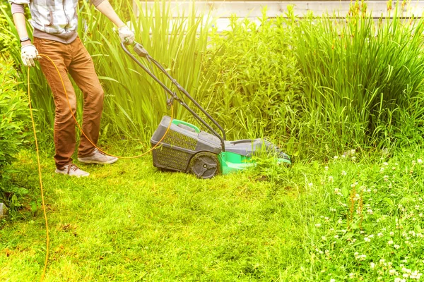 Homem cortando grama verde com cortador de grama no quintal. Jardinagem país estilo de vida fundo. Bela vista no gramado de grama verde fresco na luz solar, paisagem do jardim na primavera ou temporada de verão. — Fotografia de Stock