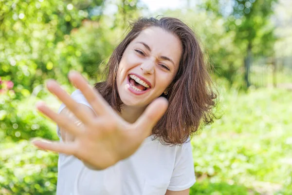 Šťastná dívka se usmívá. Krása portrét mladá šťastná, smějící se brunetka v parku nebo v zahradě — Stock fotografie