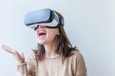 Beyaz arka planda sanal gerçeklik gözlüğü başlığı takan genç kadın gülümse. Sanal gerçeklik gözlüğü takan akıllı telefon. Teknoloji, simülasyon, yüksek teknoloji, video oyunu konsepti.