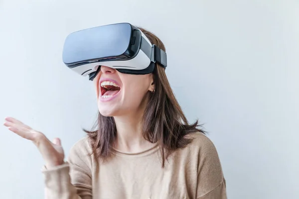 Sonríe mujer joven usando realidad virtual gafas VR casco auriculares sobre fondo blanco. Smartphone con gafas de realidad virtual. Tecnología, simulación, alta tecnología, concepto de videojuego. — Foto de Stock