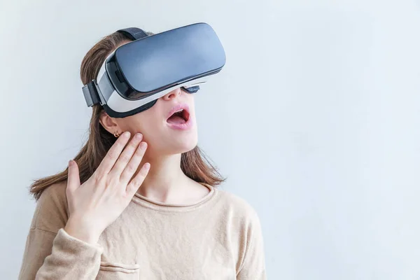 Sonríe mujer joven usando realidad virtual gafas VR casco auriculares sobre fondo blanco. Smartphone con gafas de realidad virtual. Tecnología, simulación, alta tecnología, concepto de videojuego. — Foto de Stock