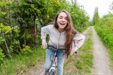 Yaz şehir parkı açık havada bisiklete binen genç kadın. Aktif insanlar. Hipster kız dinlenmek ve binici bisiklet
