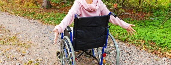 Young happy handicap woman in wheelchair on road in hospital park enjoying freedom. Paralyzed girl in invalid chair for disabled people outdoor in nature. Rehabilitation concept. — Stock Photo, Image