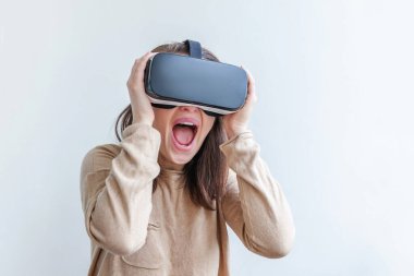 Beyaz arka planda sanal gerçeklik gözlüğü başlığı takan genç kadın gülümse. Sanal gerçeklik gözlüğü takan akıllı telefon. Teknoloji, simülasyon, yüksek teknoloji, video oyunu konsepti.