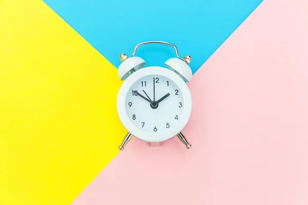 Vintage alarm klok geïsoleerd op blauw geel roze pastel kleurrijke trendy geometrische achtergrond — Stockfoto