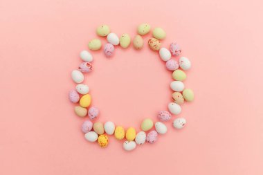 Mutlu Paskalya konsepti. Paskalya şekeri çikolata yumurta ve Jellybean tatlılar trendy pastel pembe arka planda izole. Basit minimalizm düz üst görünüm kopya alanı yatıyordu