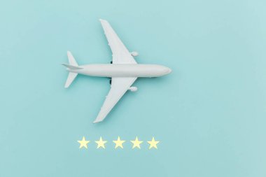 Sadece düz dizayn edilmiş minyatür oyuncak model uçak ve mavi renkli arka planda 5 yıldız. Yaz tatilinde uçakla seyahat deniz macerası yolculuk bileti konsepti.