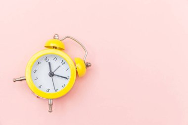 Pembe renkli renkli pastel arka planda izole edilmiş klasik alarmlı ikiz zil çalar saati. Hayatın dinlenme saatleri. İyi sabahlar. Uyanık kalma kavramı. Düz görünüm kopyalama alanı.