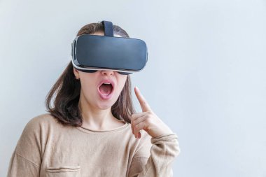 Beyaz arka planda sanal gerçeklik gözlüğü başlığı takan genç kadın gülümse. Sanal gerçeklik gözlüğü takan akıllı telefon. Teknoloji, simülasyon, yüksek teknoloji, video oyunu konsepti.