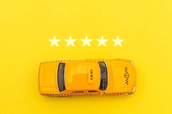 Coche de juguete amarillo Taxi Cab y clasificación de 5 estrellas aislado sobre fondo amarillo. Aplicación de Smartphone del servicio de taxi para la búsqueda en línea llamando y reservando el concepto de cabina. Símbolo taxi. Copiar espacio . — Foto de Stock