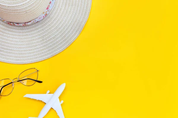 Summer beach composition. Minimal simple flat lay with plane sunglasses and hat isolated on yellow background. Vacation travel adventure trip concept. Top view copy space. — Stock Photo, Image