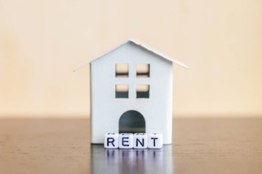 Minyatür oyuncak model ev kira harf kelime ahşap zemin üzerinde yazıt ile. Eko Köyü, çevre arka plan. Emlak mortgage Emlak sigorta tatlı ev ekoloji kira kavramı